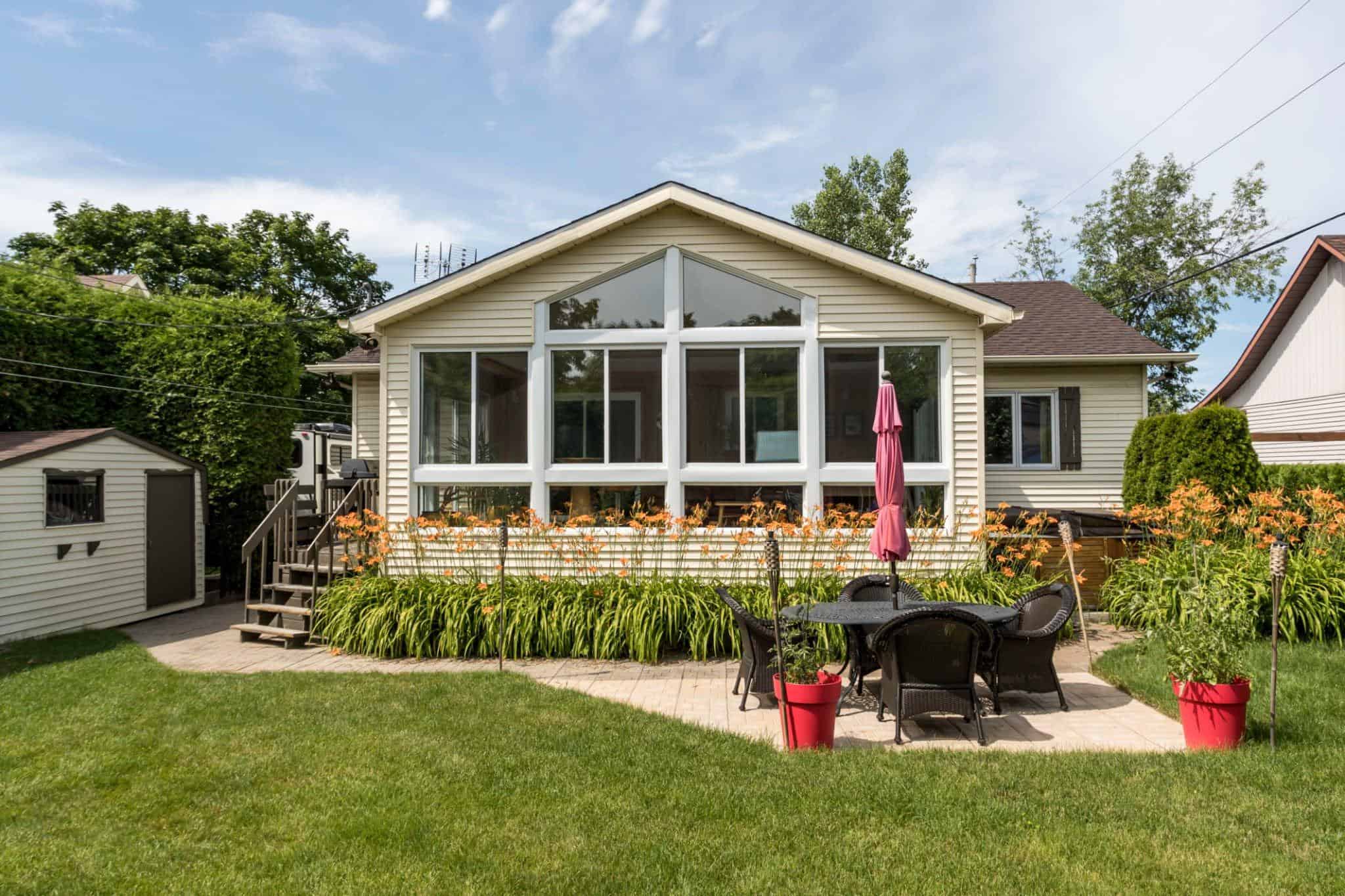 Home with an attached sunroom, with door and stairs leading to an outdoor patio in Little River, SC